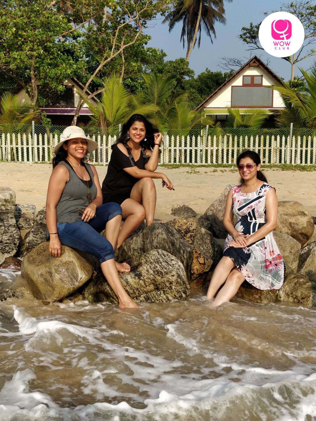 Women travellers sitting by the sea shore in Marari Beach, Kerala