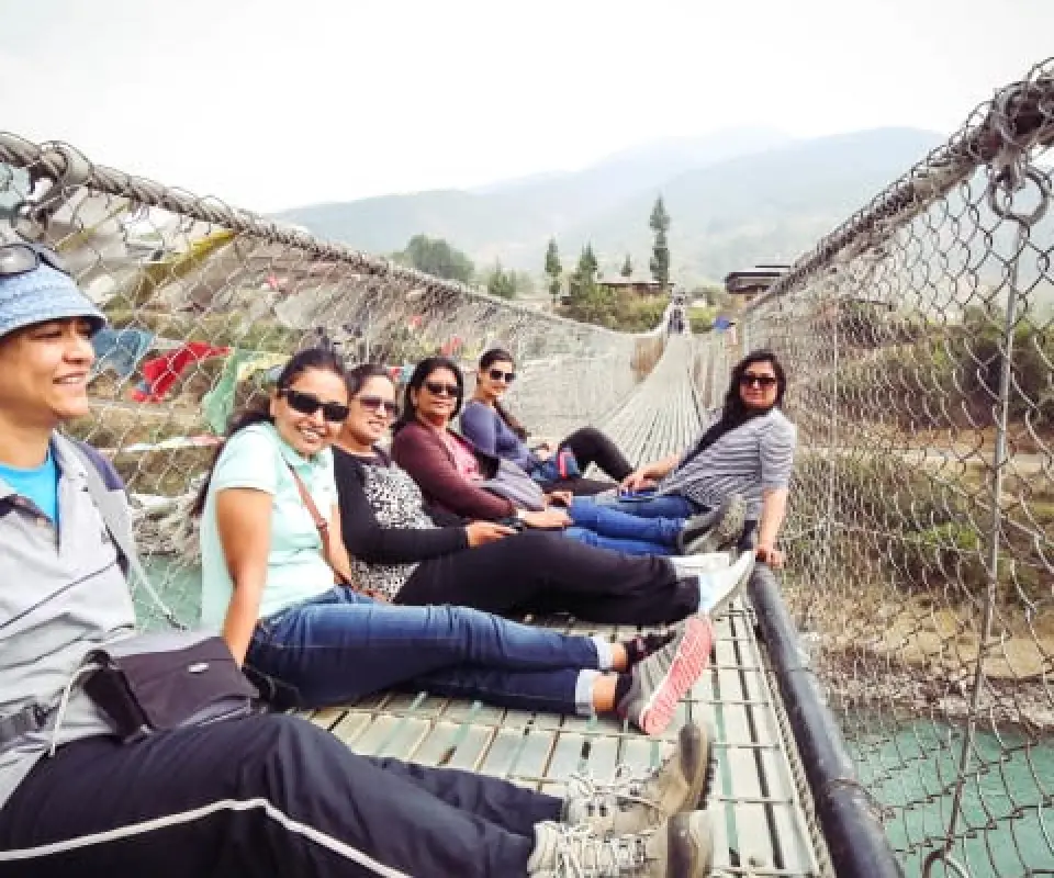 WOW Club travellers sitting on the Punakha suspension bridge in Bhutan