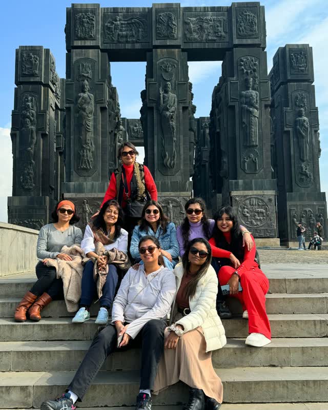 A WOW Club group seated on the steps of a carved stone monument